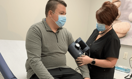 nurse testing for COVID symptoms and flu symptoms in an immediate care